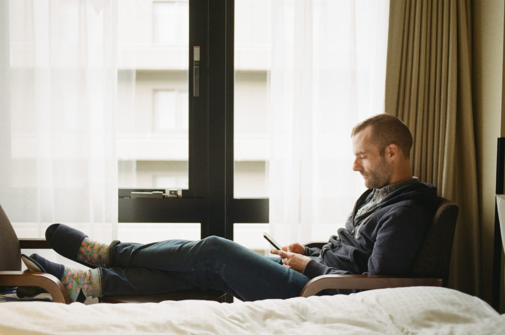 man sitting by window in hotel room