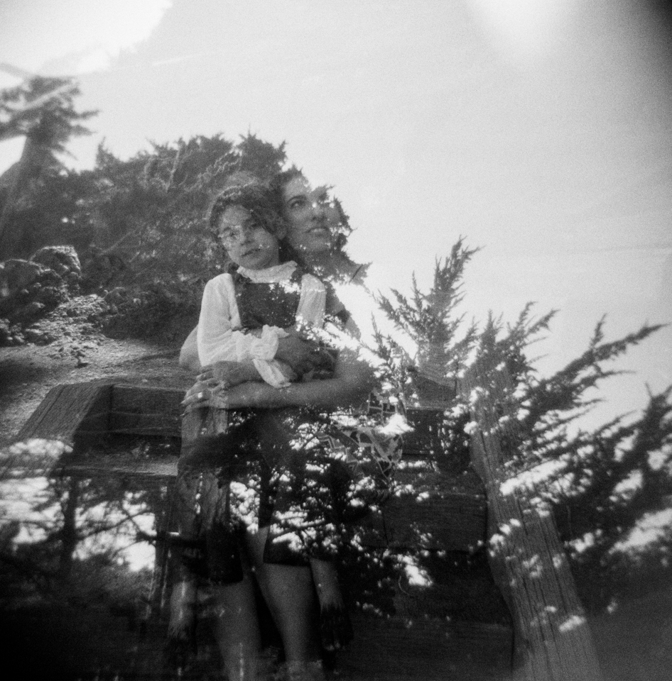 double exposure of mother and daughter with pine trees