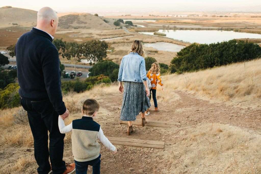 family holding hands and walking down stairs down the side of a hill