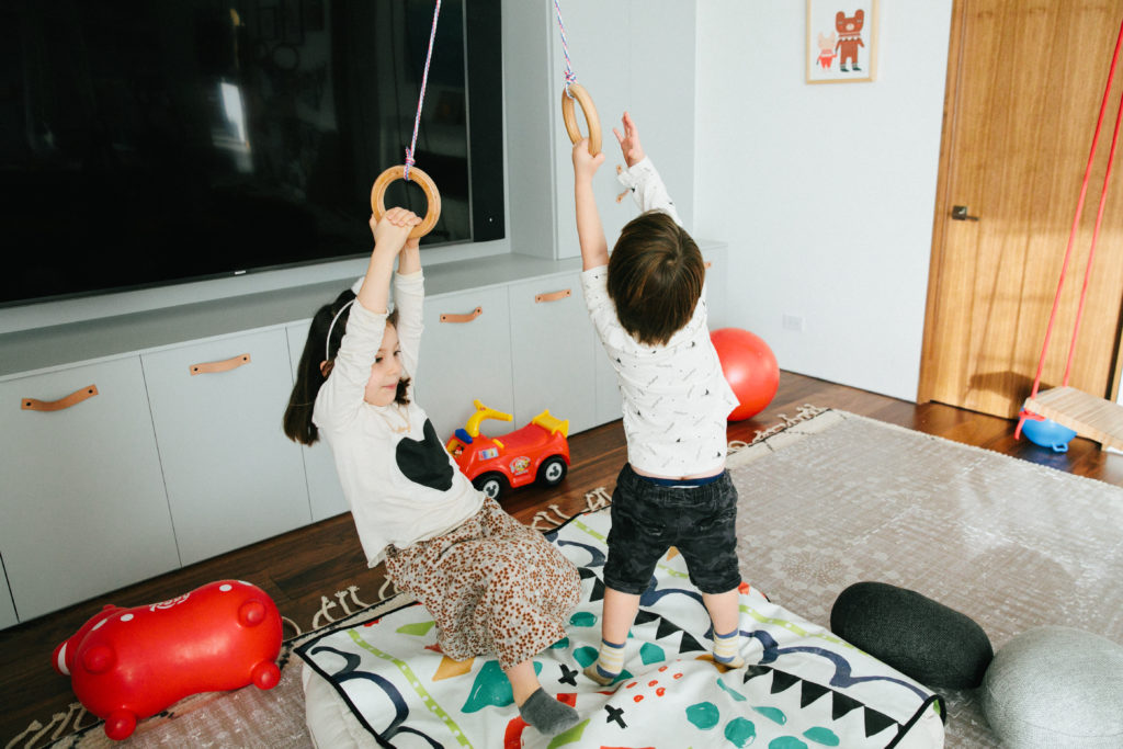 kids hanging from gymnastics rings in play room