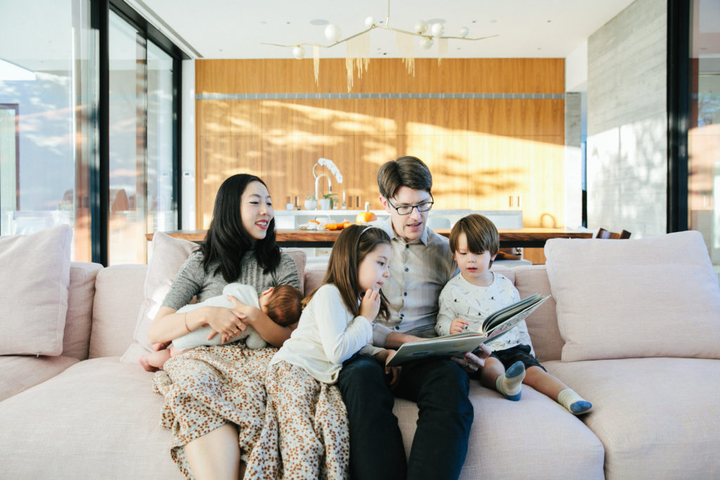 family of five reading together on couch