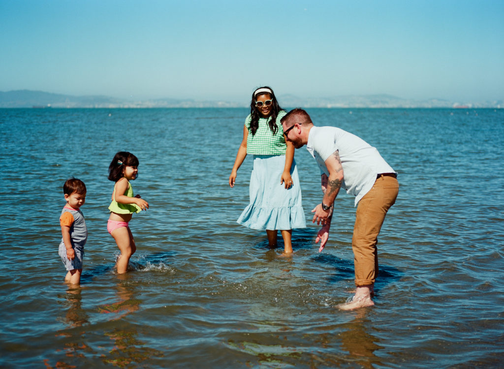 family of four in the ocean splashing