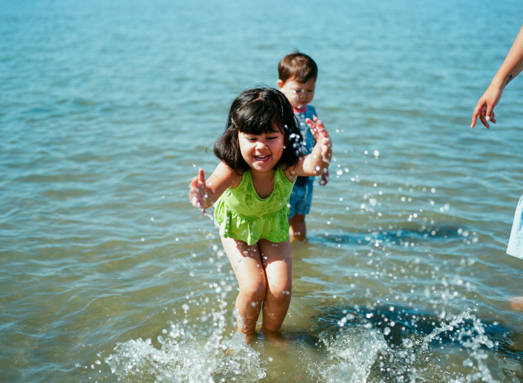 young girl splashing in ocean