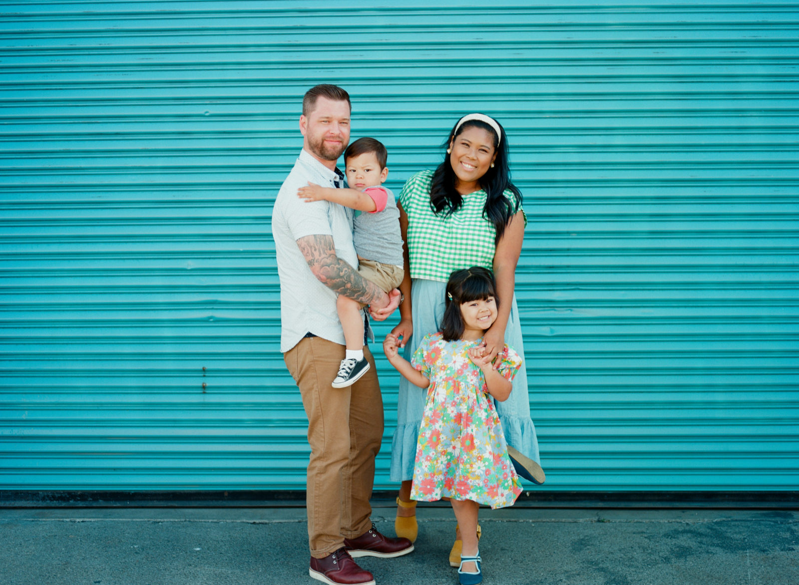 family of four standing in front of blue wall