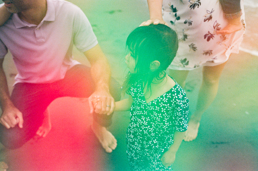 light leaked photo of young girl holding dad's hand