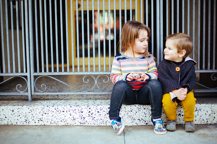 two kids sitting on stoop talking