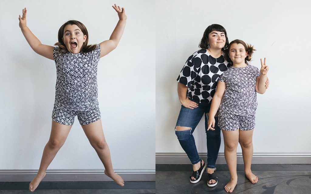 A girl jumps with wearing a matching black and white monochromatic print outfit for family photos in the Bay Area