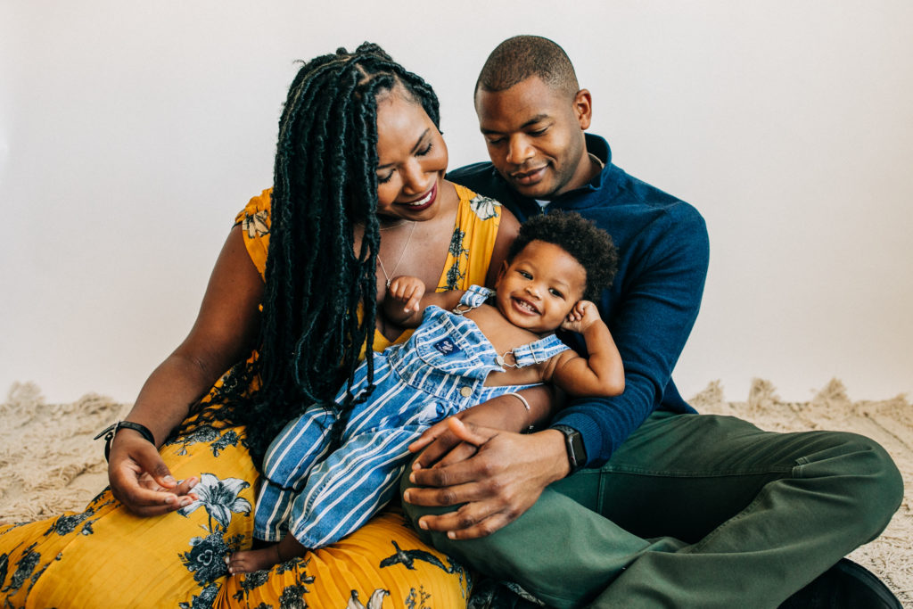 A father and mother hold their adorable song together while posing for a family photography session with Hi + Hello Photography in the Bay Area