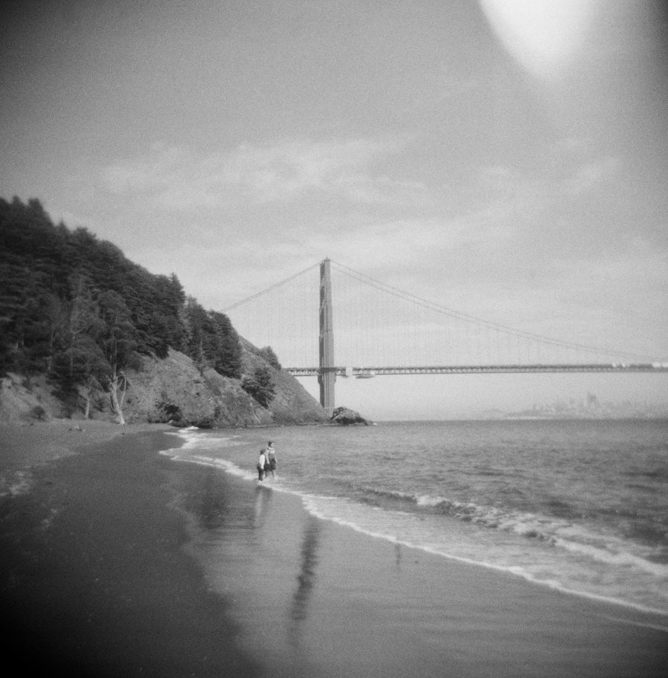 black and white image of the beach under golden gate bridge in san francisco