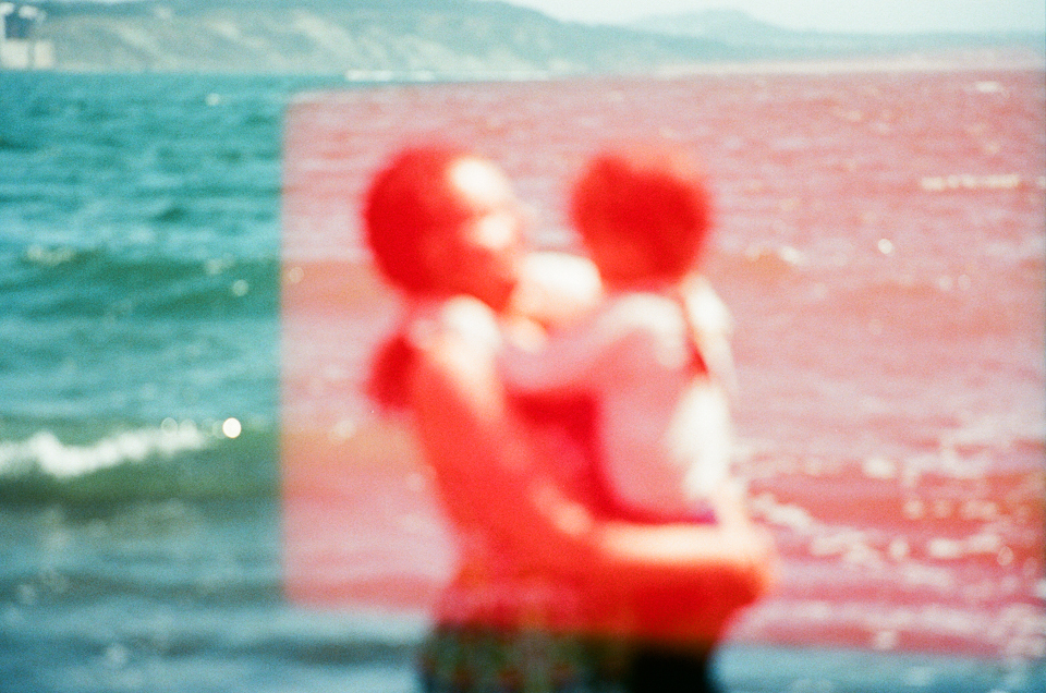 out of focus image of mother holding daughter with light leaks