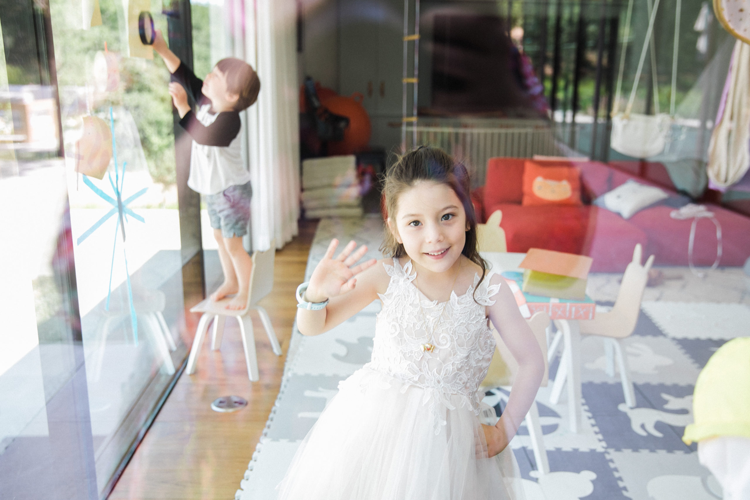 girl in white dress photographed through a window