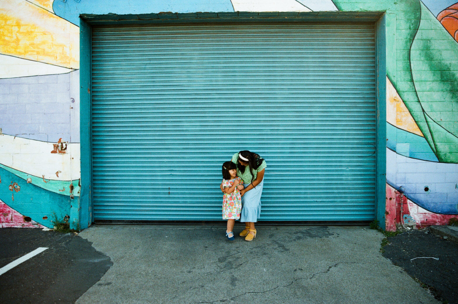 wide shot of mom and daughter in front of warehouse door