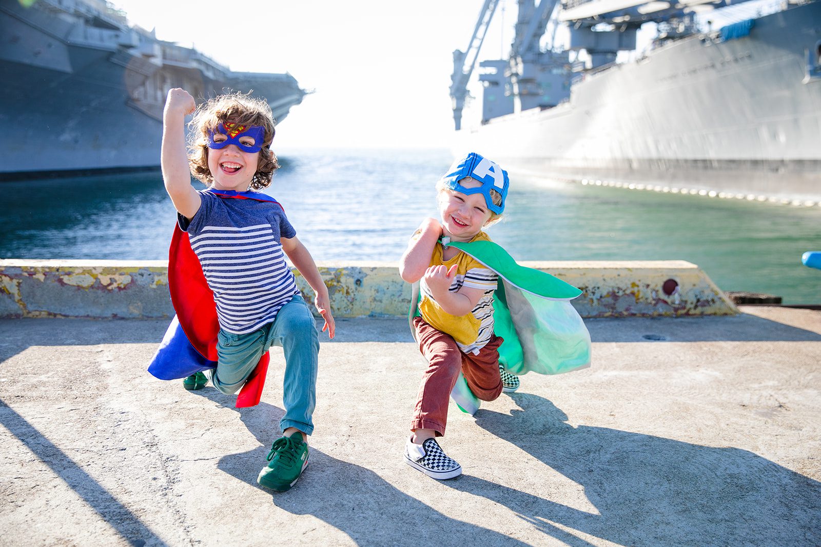 photo of two young boys in super hero costumes posing in front of the USS Hornet in Alameda California